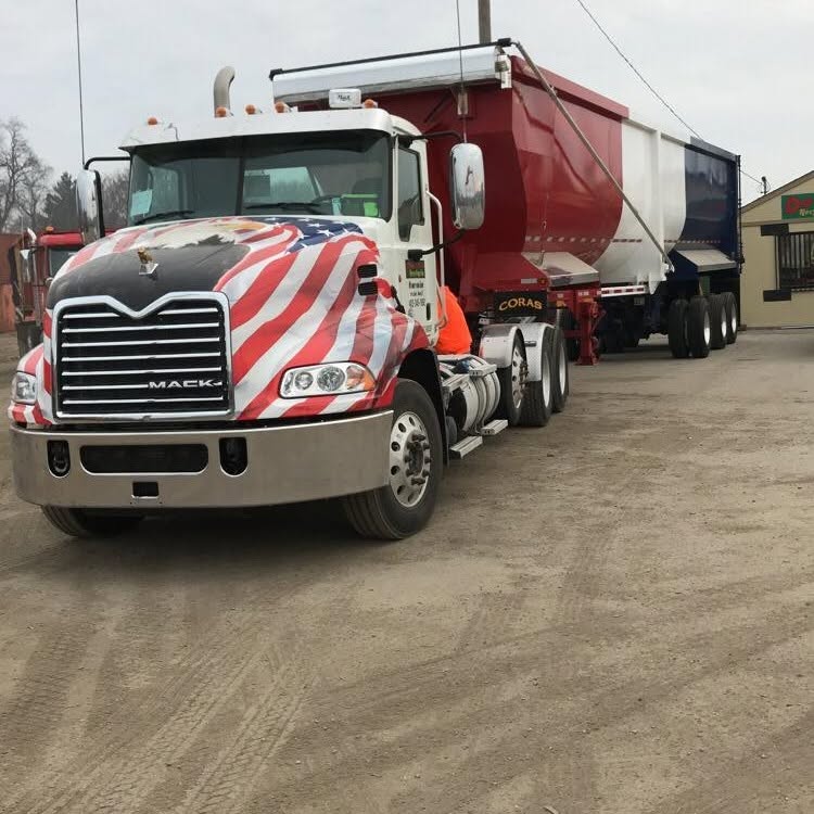 Downtown Recycling semi with a flag-wrapped cab and dump trailer